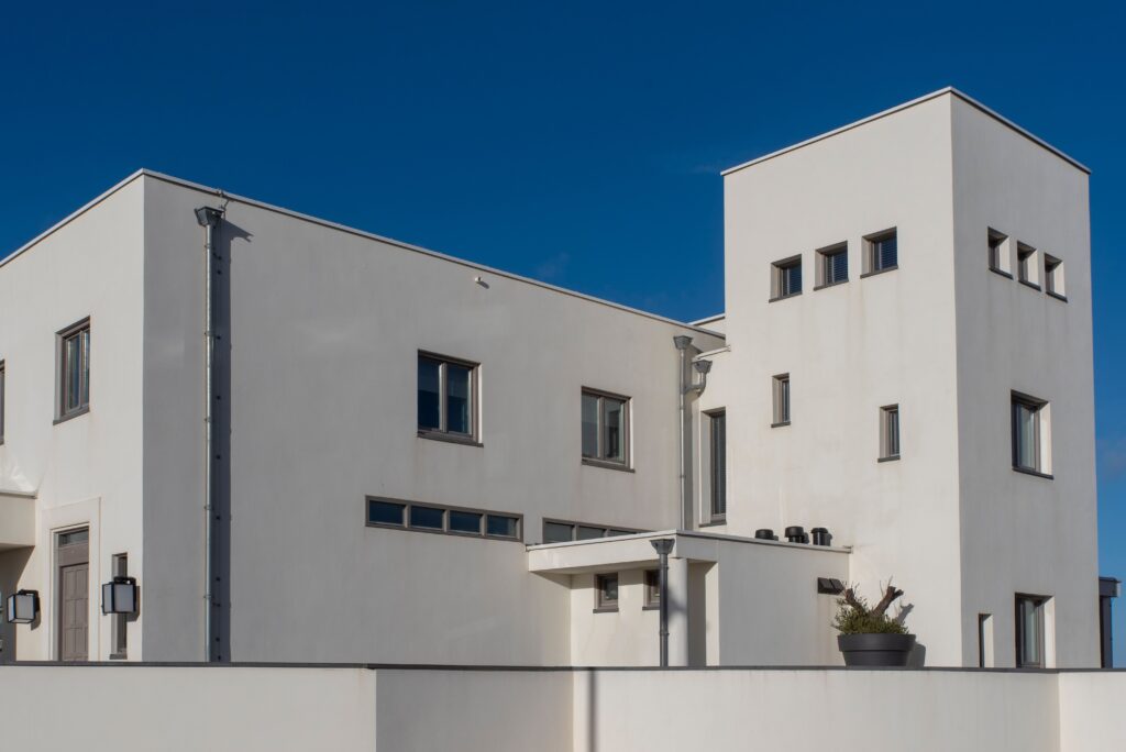 Elegant modern architecture of a white house under clear blue sky in Katwijk aan Zee, Netherlands.
